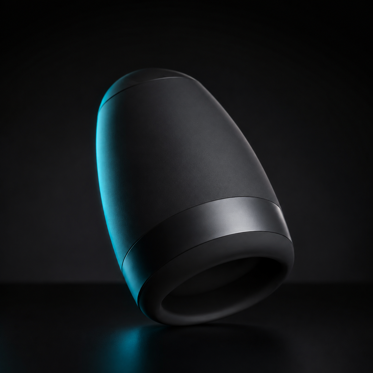 Original editorial render of a compact matte-black warming and vibrating wellness device